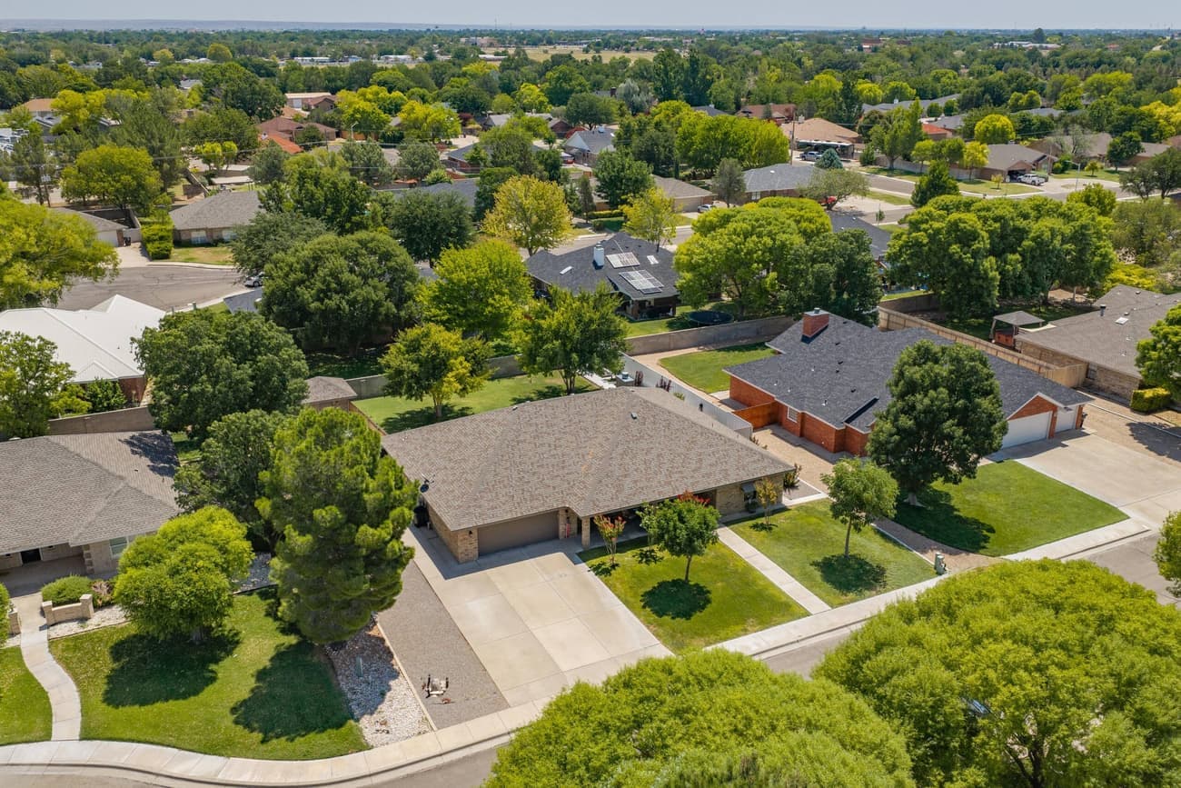 A wide view of the property's mature landscaping and lawn.